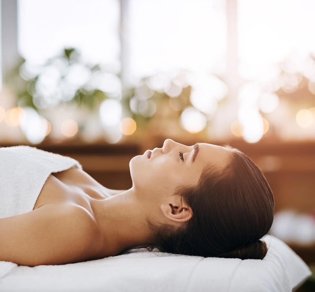 a woman lying on her back on a massage bed