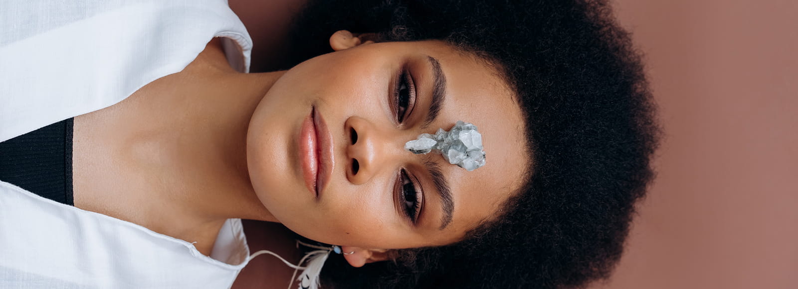 woman lying on her back with petals on her forehead
